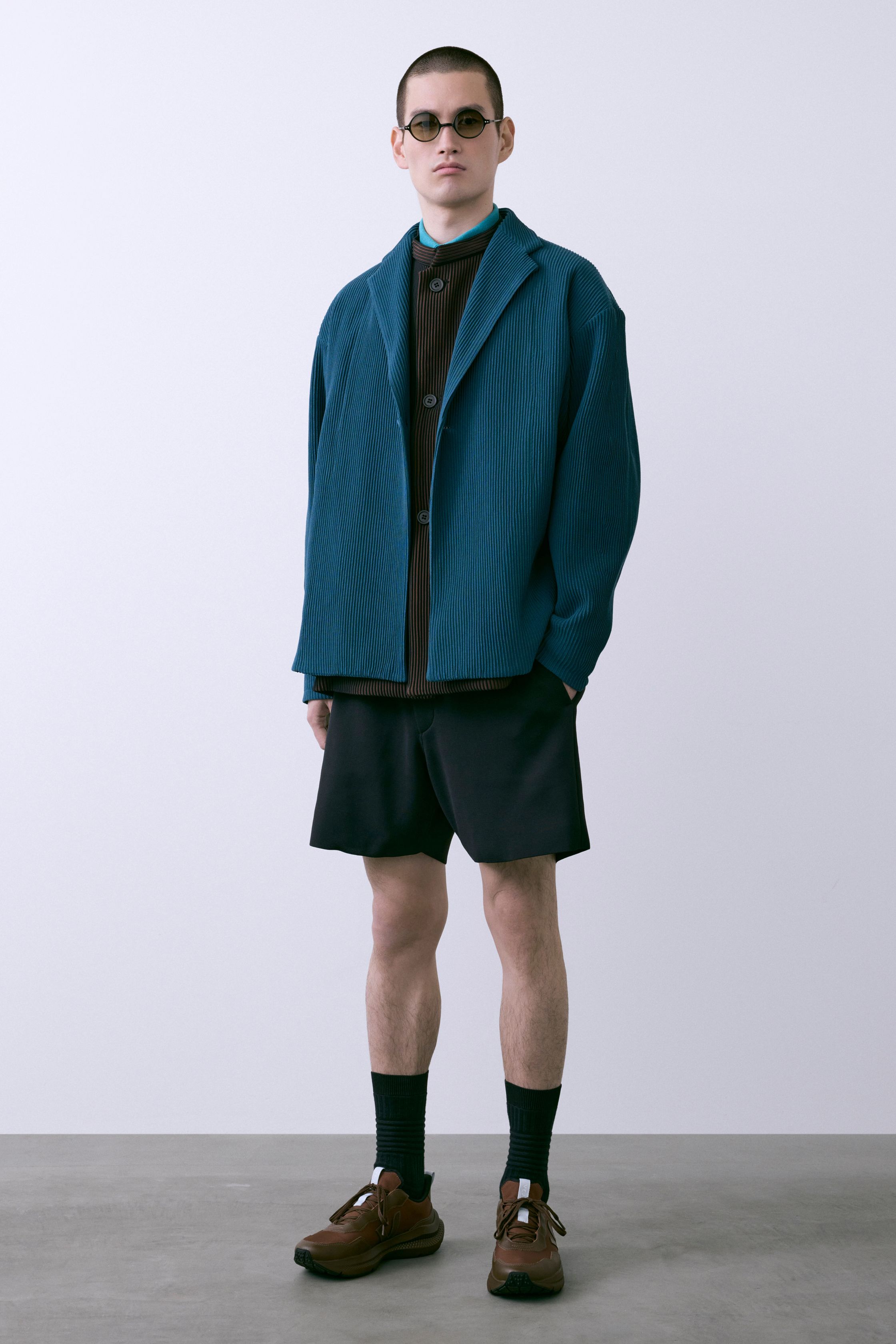 CFCL 26FW 以计算机针织为核心语言，将服装转化为可被“阅读”的结构体。纵向纹理、立体褶皱与模块化比例在黑、深蓝与青绿色中展现理性秩序，既冷静又富有身体律动。系列强调零浪费与可持续逻辑，在极简外观下隐藏高度技术复杂性，构建一种介于未来制服与当代艺术之间的男装形态，是日本新世代设计中最具系统美感的表达之一-顽石频道趋势研究